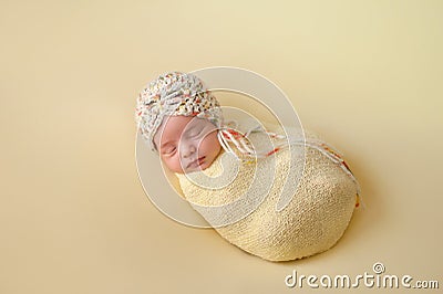 Sleeping Newborn Baby Girl Swaddled in Yellow Stock Photo