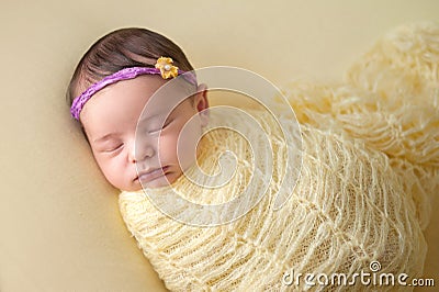 Sleeping Newborn Baby Girl Swaddled in Yellow Stock Photo