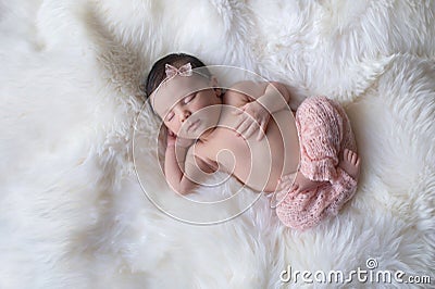 Newborn Baby Girl Sleeping on White Sheepskin Rug Stock Photo