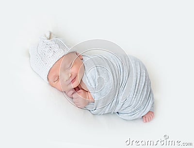 Sleeping newborn baby swaddled in a light blue wrap Stock Photo