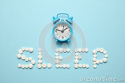 Sleeping pills and an alarm clock, insomnia concept. Trouble falling asleep Stock Photo