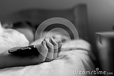 Sleeping teenage boy holding hes smartphone, conceptual image of smartphone addiction Stock Photo