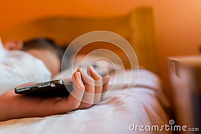 Sleeping teenage boy holding hes smartphone, conceptual image Stock Photo