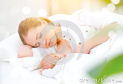 Sleeping together and breastfeeding mother and newborn baby in b Stock Photo
