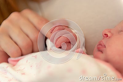 Week old baby holding mother`s finger Stock Photo