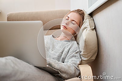 Sleeping woman in gray home suit with laptop Stock Photo