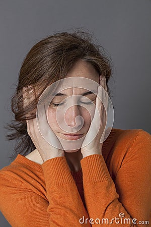Sleepy beautiful middle aged woman holding her face for reassurance Stock Photo