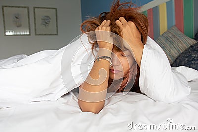 Sleepy drowsy young woman suffering hangover headache with eyes closed in bed at home.Insomnia woman migraine headache ï¿¼in Stock Photo