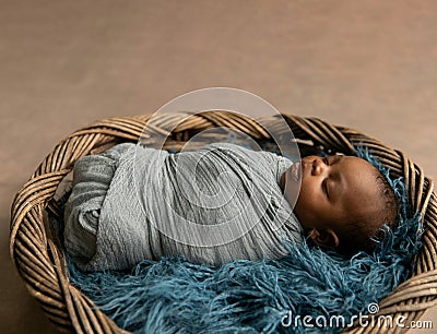 Sleepy swaddled African-American newborn baby boy Stock Photo