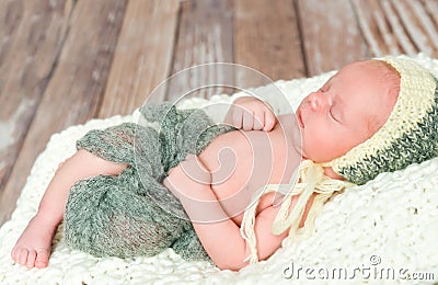Sleepy swaddled newborn baby in knitted hat Stock Photo