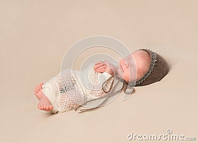 Sleepy swaddled newborn baby in knitted hat Stock Photo