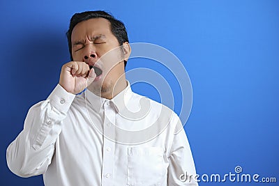 Sleepy tired Asian businessman yawning Stock Photo