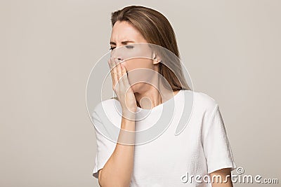 Sleepy tired young woman yawning, covering mouth with hand Stock Photo