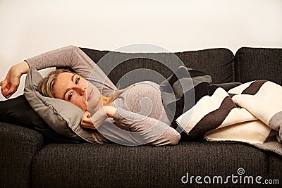 Sleepy Woman Reclining On Sofa Stock Photo
