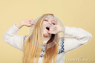 Sleepy yawning teenage woman in jumper Stock Photo