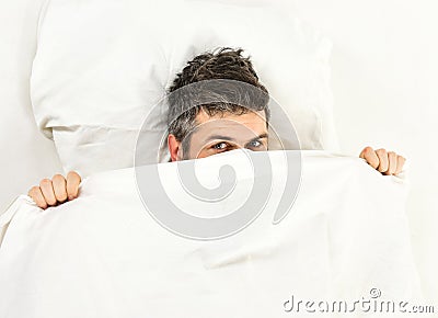 Sleepyhead concept. Man with sleepy face lies on pillow Stock Photo