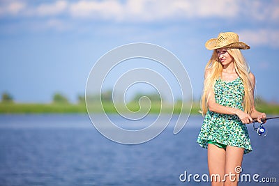 Young blonde girl fishing in lake Stock Photo