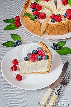 Slice of cheesecake with fresh berries on the white plate close up - healthy organic dessert. Classic New York cheese cake Stock Photo