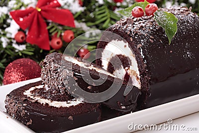 Slice of Christmas yule log cake on plate with decoration Stock Photo