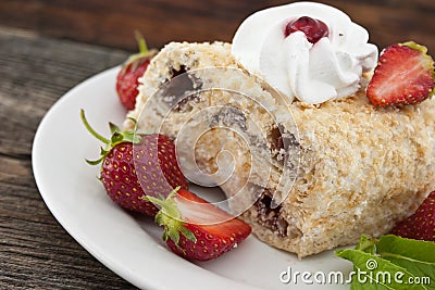 Slice of cream puff cake with strawberry on wooden table Stock Photo