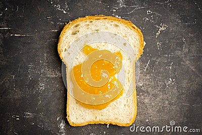 Slice of freshly baked rural bread with homemade citrus jam. Selective focus Stock Photo