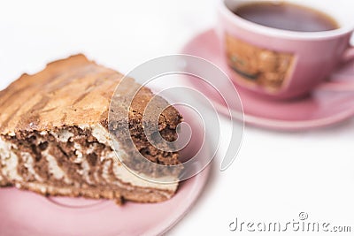 A slice of a homemade Zebra pie on a saucer mauve pink colour and a cup of tea on a saucer in a defocus Stock Photo