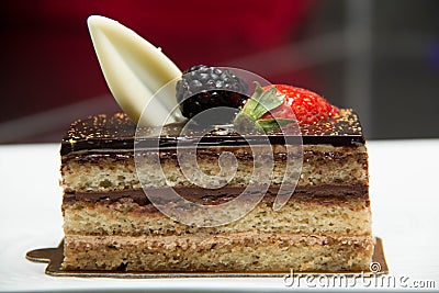 Slice of layered chocolate cake topped with a strawberry and bl Stock Photo