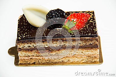 Slice of layered chocolate cake topped with a strawberry and bl Stock Photo