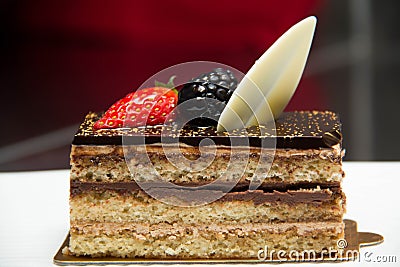 Slice of layered chocolate cake topped with a strawberry and bl Stock Photo