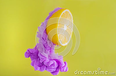 Slice lemon with partial focus of dissolving violet poster color in water Stock Photo