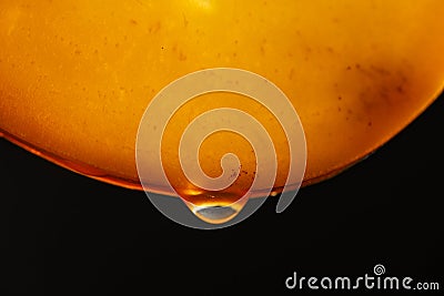 Slice of orange persimmon with juice drops on a black background, macro photography. Texture fresh fruit, closeup Stock Photo