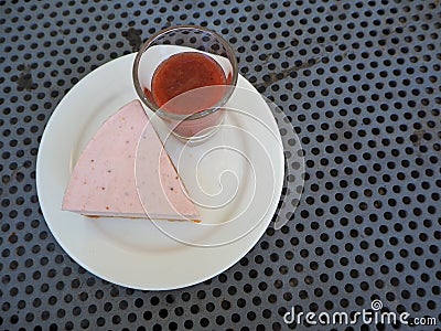 Slice of plain cheesecake with cranberry sauce on white plate decorated Stock Photo