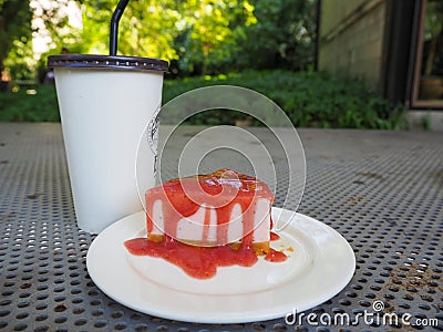 Slice of plain cheesecake with cranberry sauce on white plate decorated Stock Photo