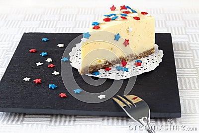 Slice plain new york cheesecake on slate board. Concept celebration of Veteran`s Day or July 4th USA. Selective focus. Copy space Stock Photo
