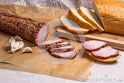 Slice smoked meat or ham, garlic and white wheat bread on brown Stock Photo