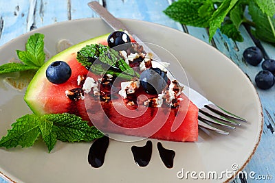 Slice of watermelon pizza close up with blueberries, feta and mint Stock Photo