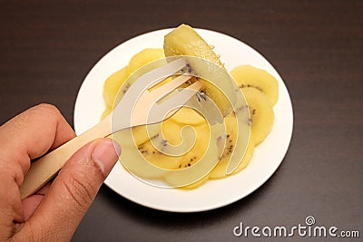 Slice of yellow kiwigold kiwi on plate. Stock Photo