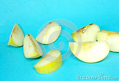 Sliced Apple on a blue background. Green Apple cut into pieces. Fresh and healthy fruits. Fresh green apples. Stock Photo