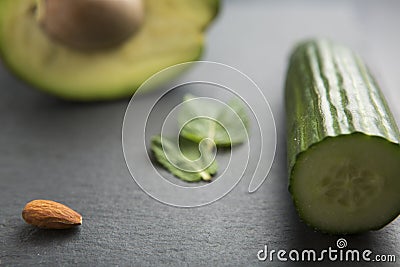 sliced avocado with almonds, mint and cucumber on dark background, selective focus Stock Photo