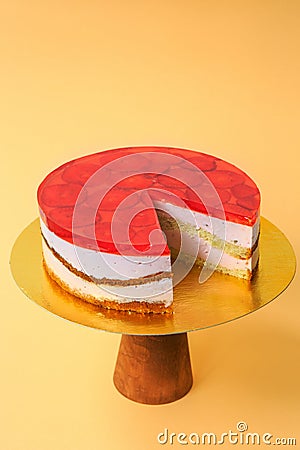 Sliced Birthday cake on the wooden cake stand. Beautiful sponge cake on the paper background. Copy space. Food photography for Stock Photo