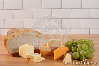 Sliced bread butter cheese blocks and green grapes Stock Photo