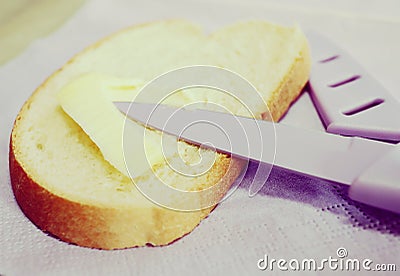 Sliced bread spread with butter or margarine and a knife Stock Photo