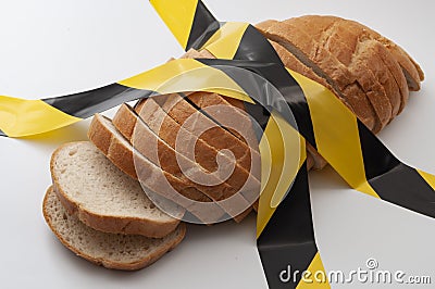 Sliced bread and yellow caution tape isolated on white background concept for food insecurity, hunger warning and hazardous Stock Photo