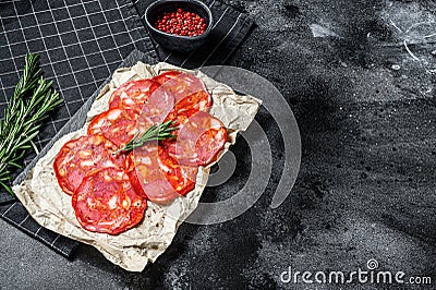 Sliced chorizo salami. Spanish traditional chorizo sausage. Black background. Top view. Space for text Stock Photo