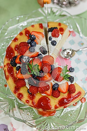 Sliced Crape Cake on top with Mixed Berries and Strawberry Sauce Stock Photo