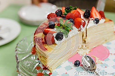 Sliced Crape Cake on top with Mixed Berries and Strawberry Sauce Stock Photo