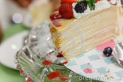 Sliced Crape Cake on top with Mixed Berries and Strawberry Sauce Stock Photo