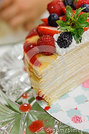 Sliced Crape Cake on top with Mixed Berries and Strawberry Sauce Stock Photo