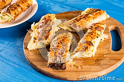 Sliced domestic cheese pie on the round wooden kitchen cutting board Stock Photo