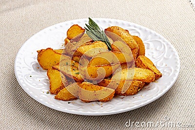Sliced fried potatoes, Creole-style with spices. On a white plate Stock Photo
